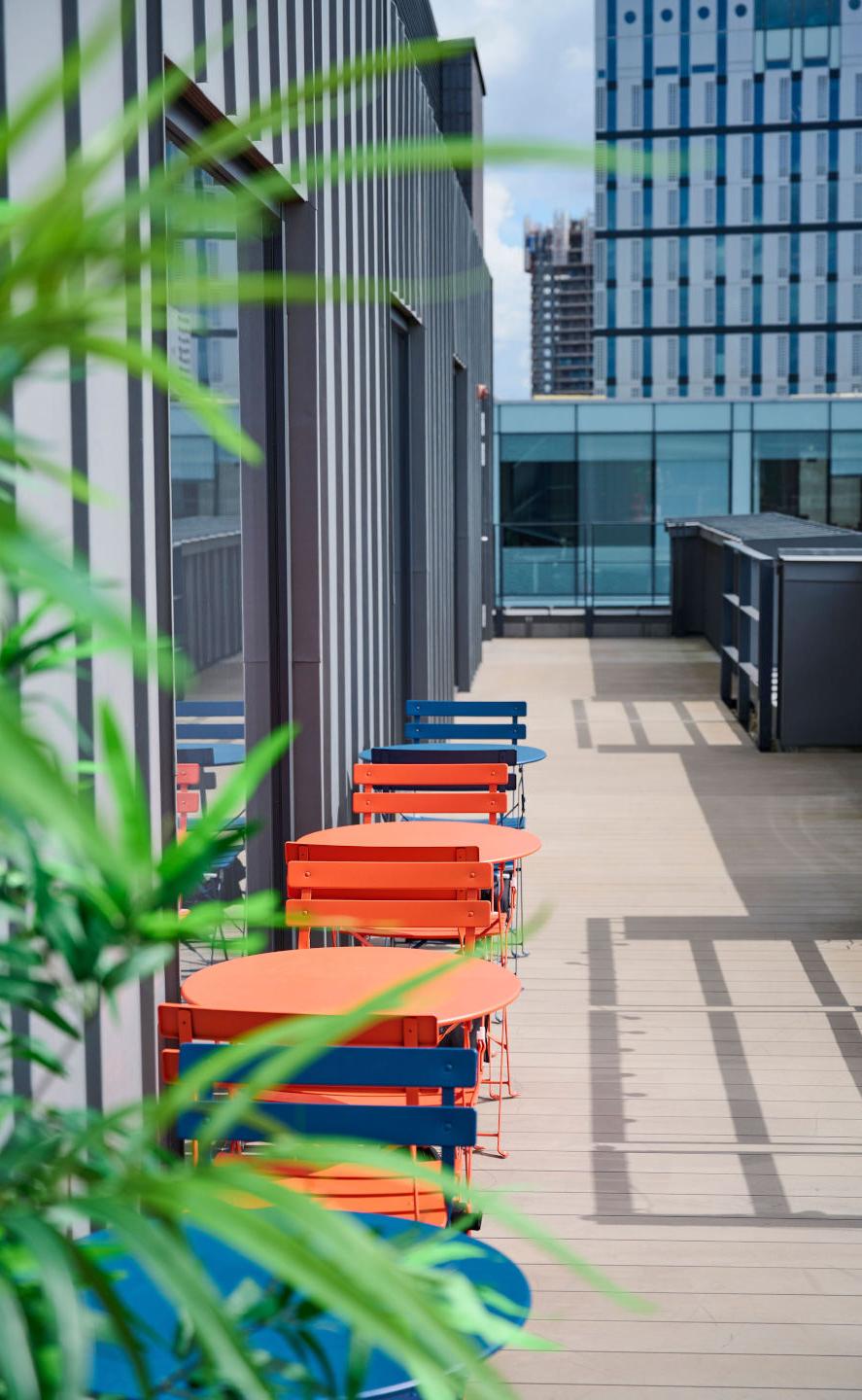 Photo of a rooftop area with tables and chairs.