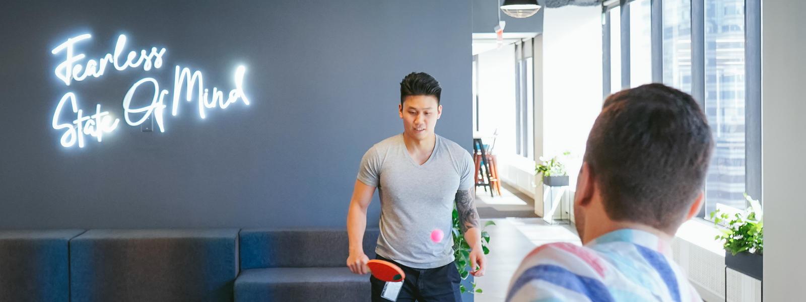 Photo of two people playing table tennis.