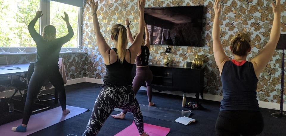 Photo of 3 people exercising in a living room.