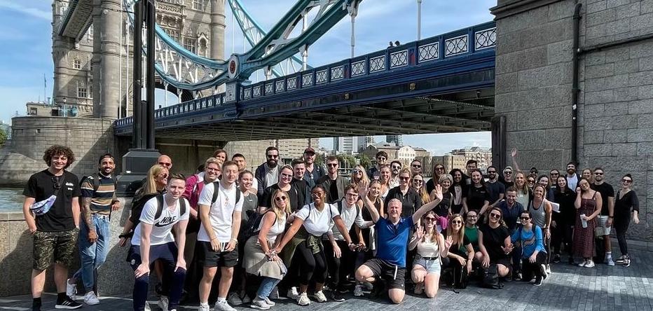 Photo of a group of people under Tower Bridge.